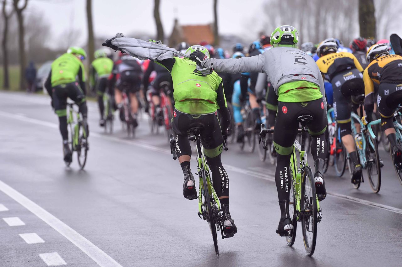Cannondale-Garmin riders trying to adjust clothing in the strong winds