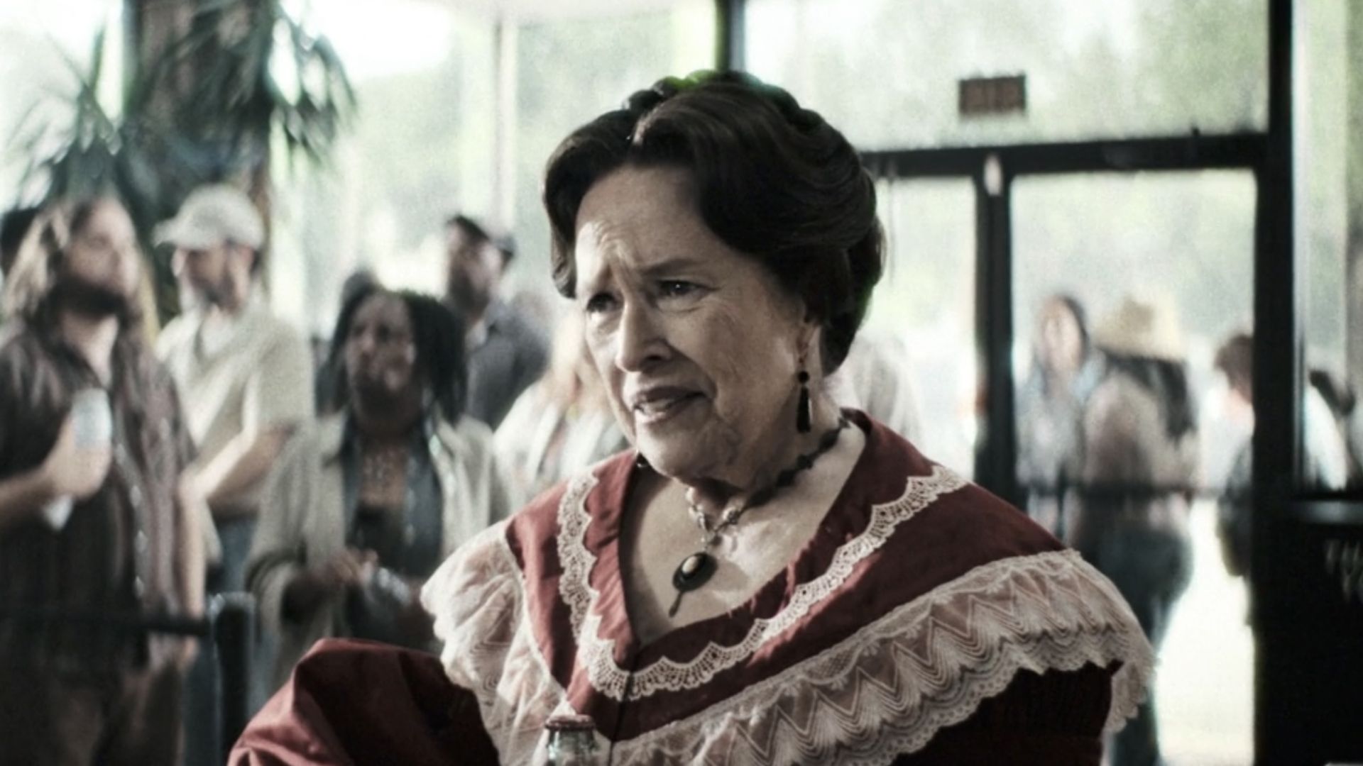 Kathy Bates' Delphine wearing a red dress at Chubby's Chicken in AHS 13