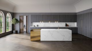 large kitchen with dark scheme and large quartz island with gold section by caesarstone
