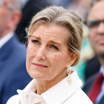 Duchess Sophie wears a white jacket and looks like she is about to cry