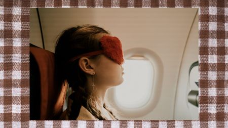 A girl with a orange fluffy eye mask on sleeping on plane on a gingham background
