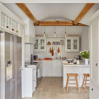 Kitchen with white walls and wooden flooring containing kitchen worktop