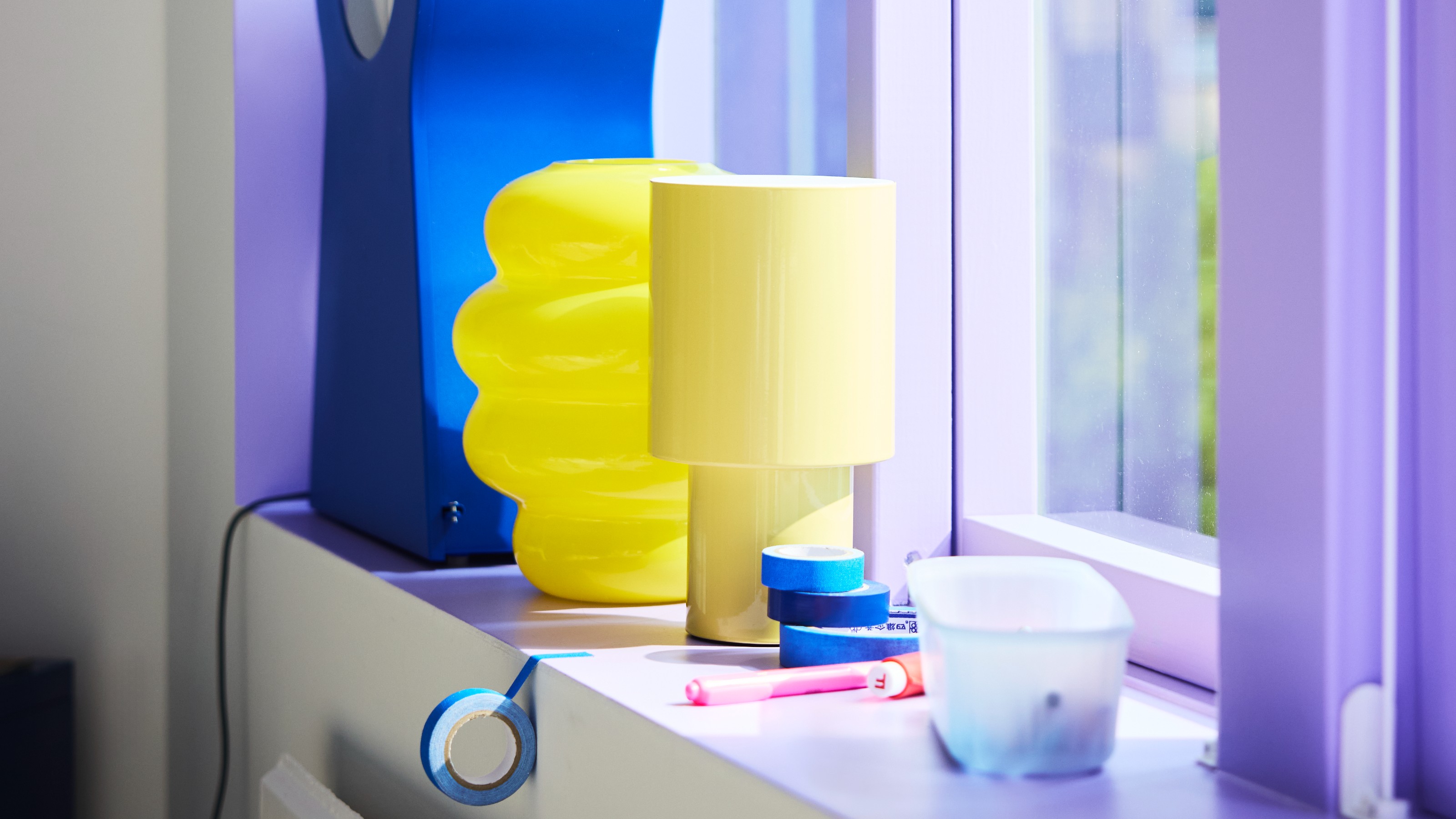 IKEA SPETSBOJ lamp in yellow on a purple-painted windowsill