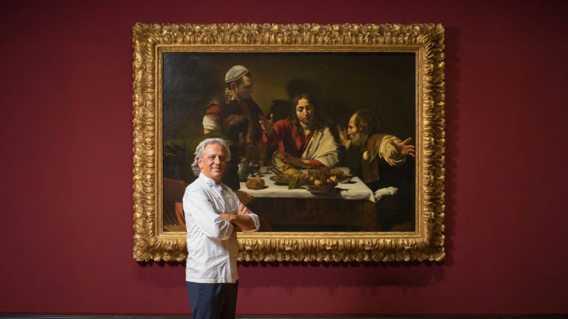 an image of Giorgio Locatelli standing in front of Caravaggio's Supper at Emmaus