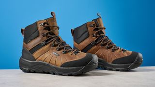 The Keen Revel IV in brown on a stone surface with a blue background