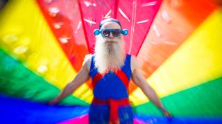 A man carries the rainbow flag as he takes part in the Brighton Pride Parade on August 6, 2016 in Brighton, England