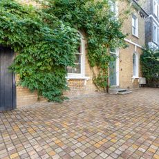 A driveway with square paving in various tones
