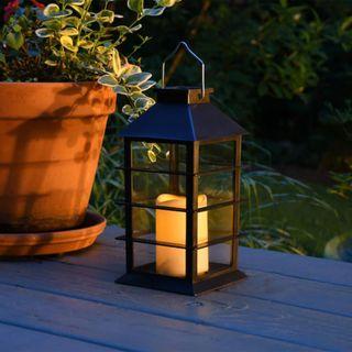 black LED candle lantern on a deck