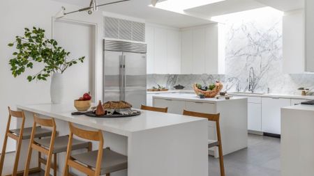 A white minimalist kitchen designed by Oaskfell Residence