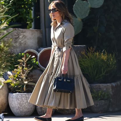 Jennifer Lopez in black Repetto ballet flats and a tan shirt dress