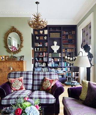 A view of the living room in in Fiona Fullerton's Georgian house in Cheltenham with colourful furnishings and a dark purple built in display bookcase.