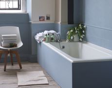 A blue bathroom with a built-in tub 