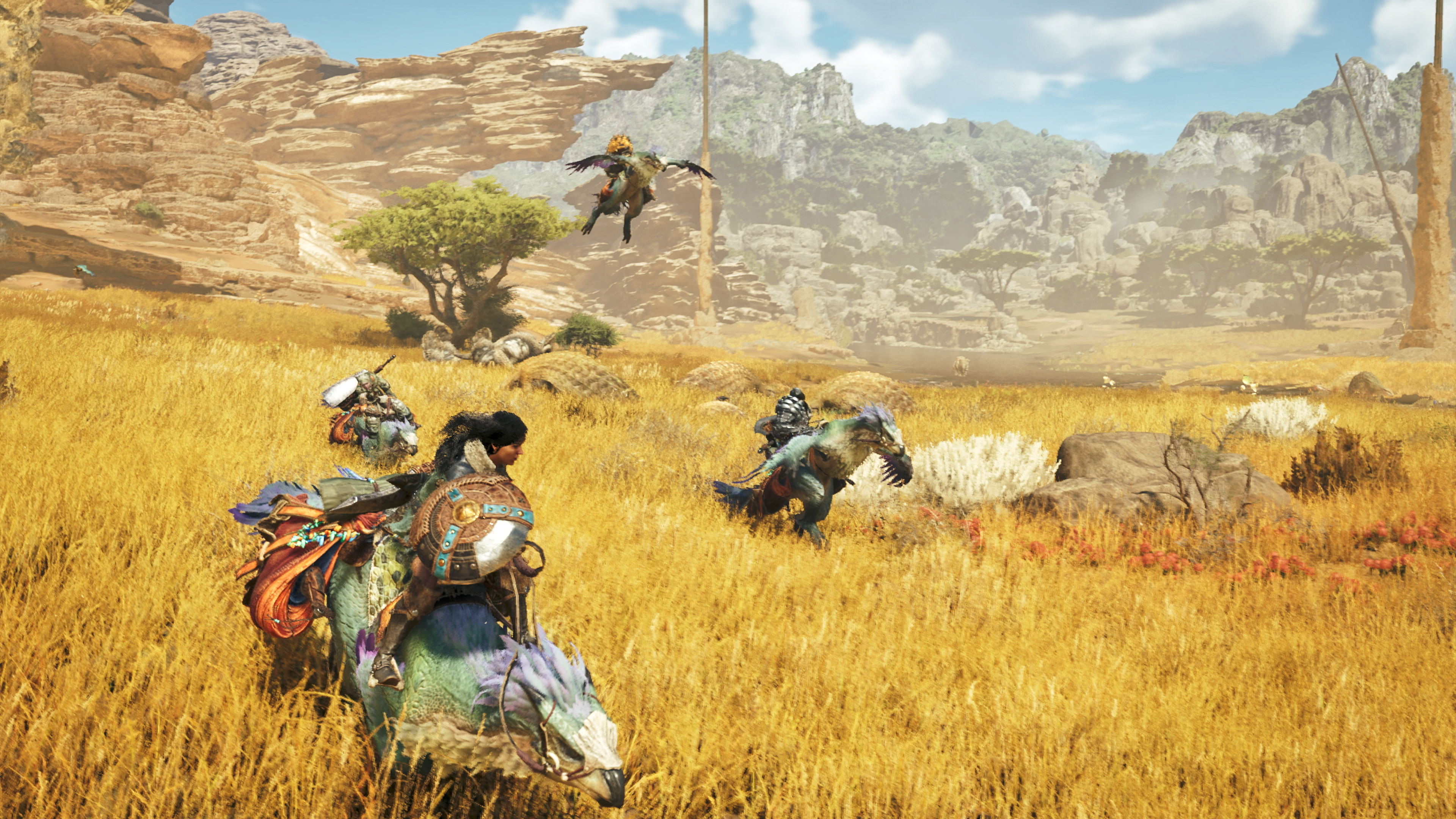 players ride across a desert plain using their Seikret mounts