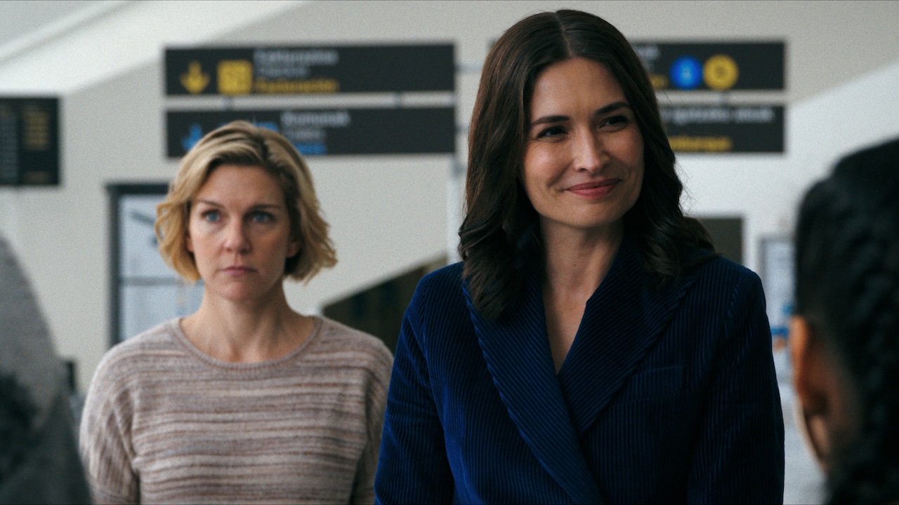 Carol and Zosia in airport talking to other survivors in Pluribus Season 1