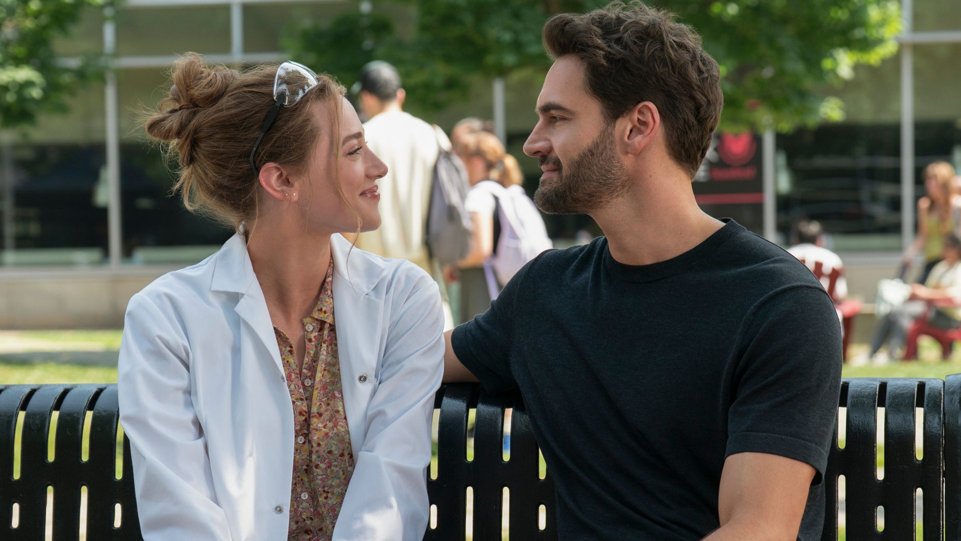 Olive and Adam gaze at each other on a bench
