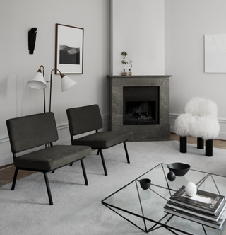 A living room with dark gray chairs and light gray walls