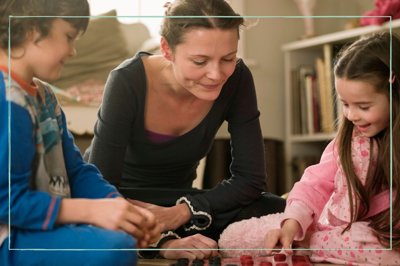 mum playing board game on the floor with her two children