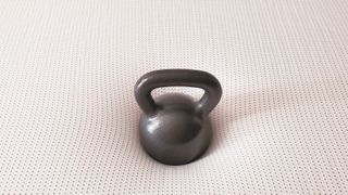A black kettlebell placed on top of the Nectar Premier Copper Mattress during testing