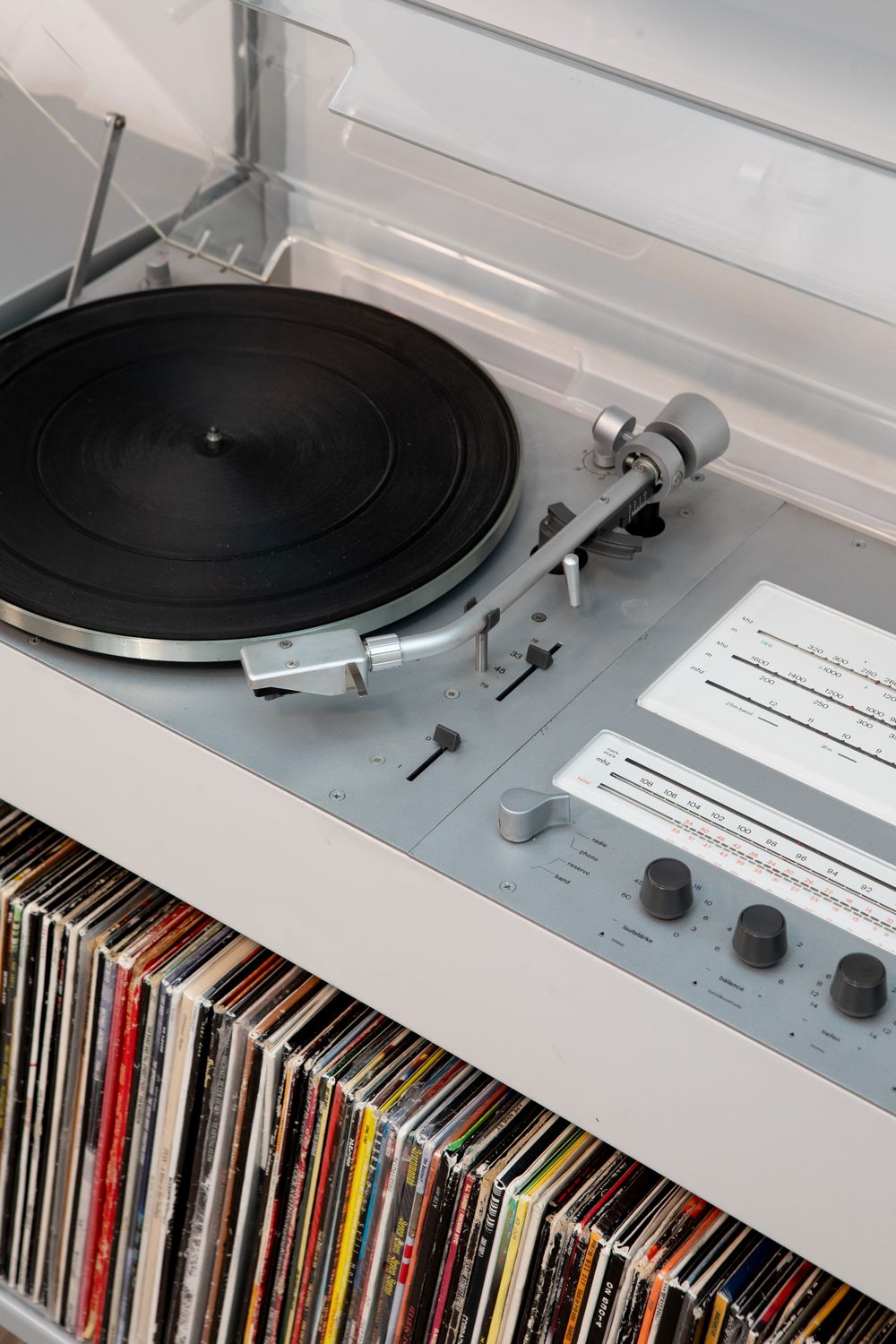 close up of record player on top of rows of records