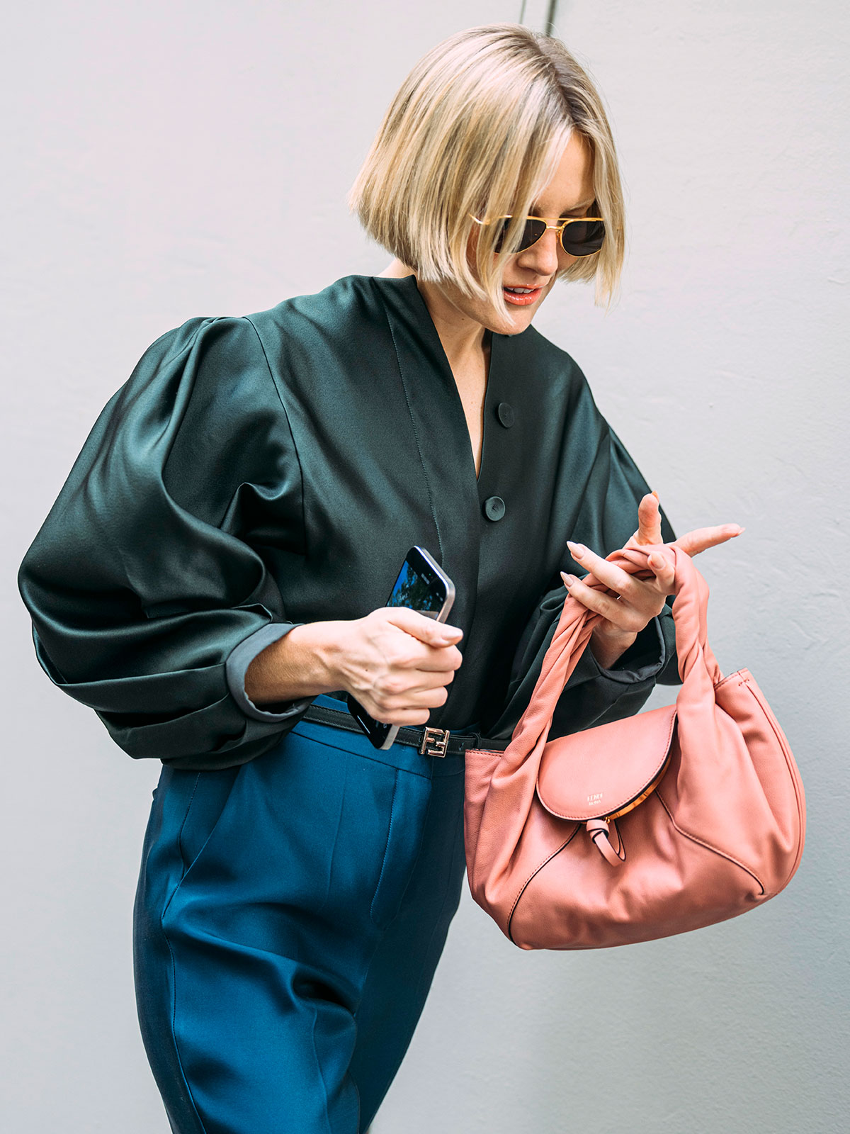 Woman carrying a pink Fendi handbag.