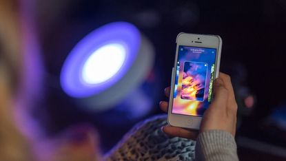 Philips Hue Iris lamp having its color-changing smart bulb controlled by a smartphone