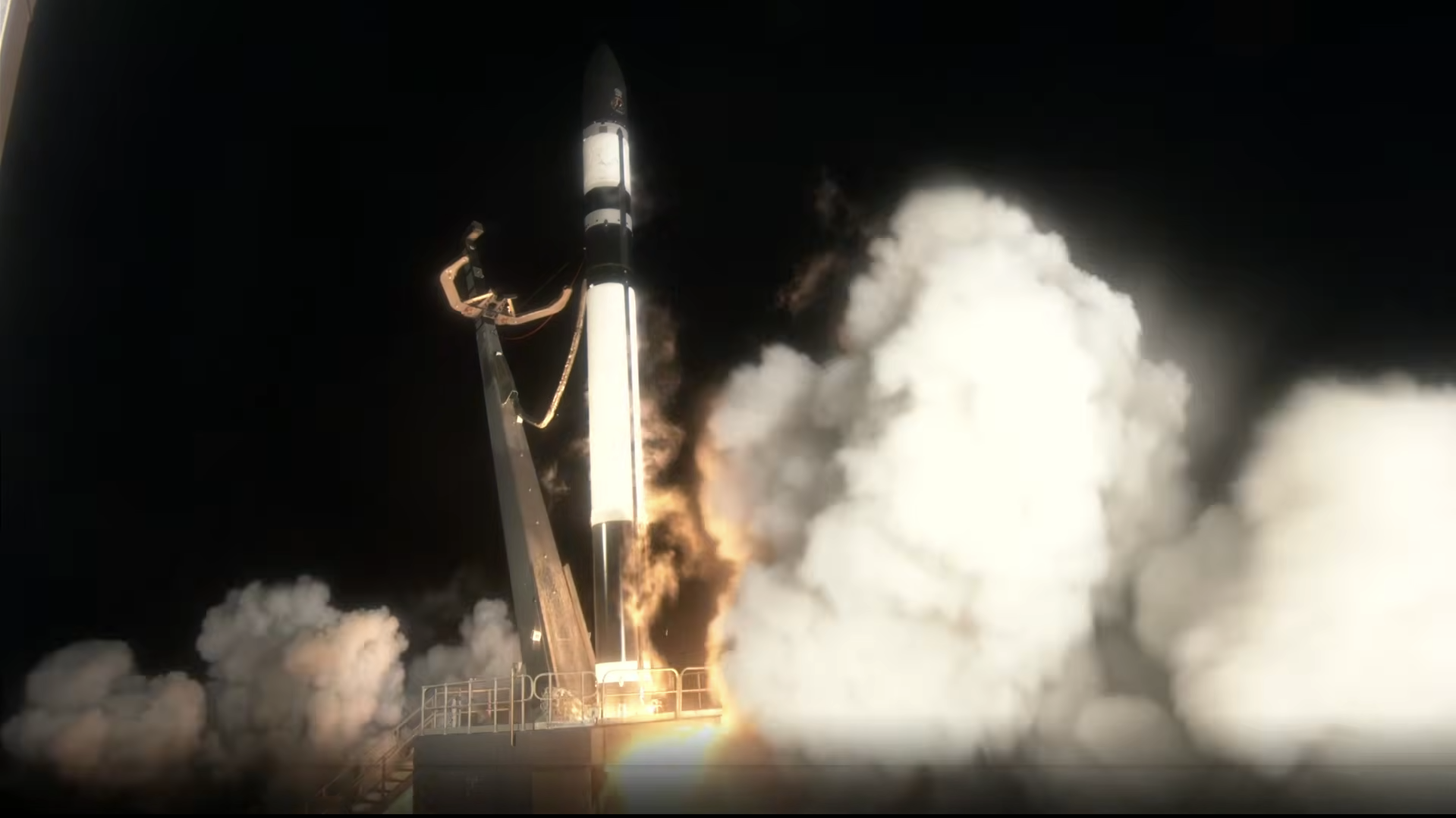 A dark rocket ignites its engines, lifting off a launch pad in a dark night setting.