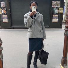 Sylvie Mus wearing a knee-length skirt with knee-high boots. 