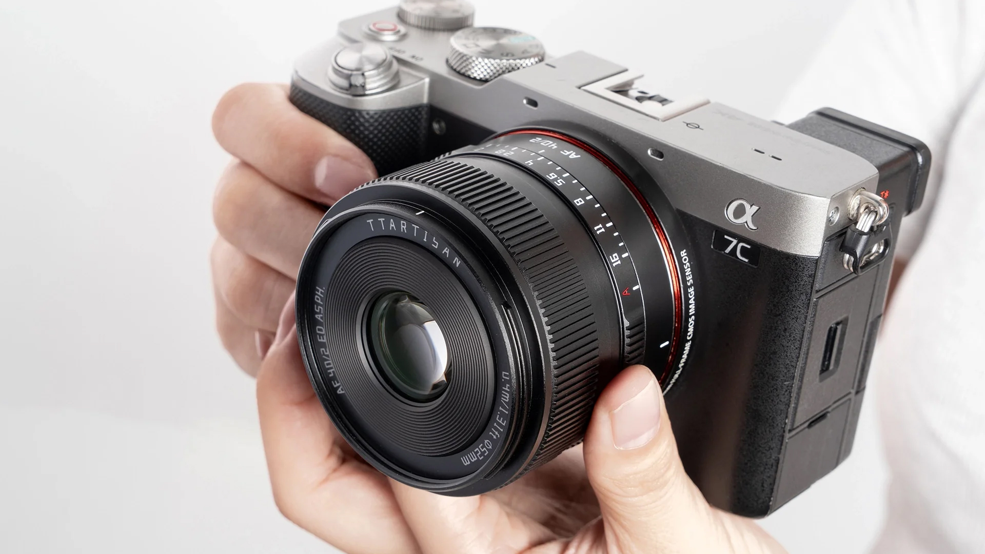 The TTArtisan AF 40mm f/2 held in a photographer's hands