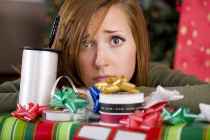Young woman looking distressed surrounded by Christmas presents