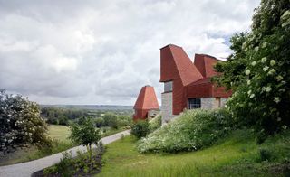 The red clay-tiled peaked towers reference the traditional rural oast house which can be found in the local area
