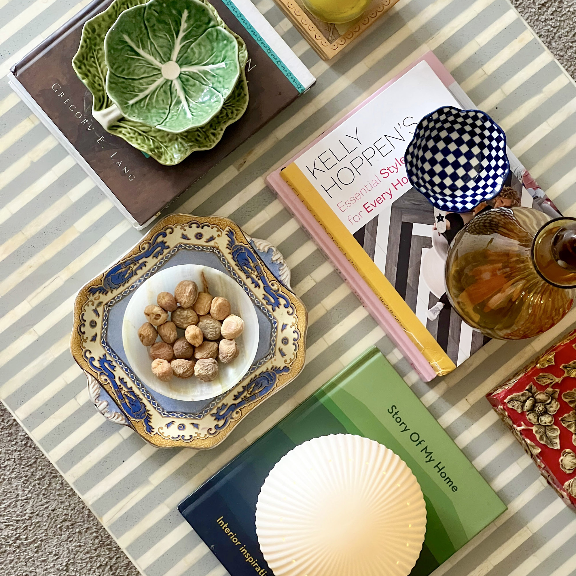 trinket trays on a stripy coffee table with books