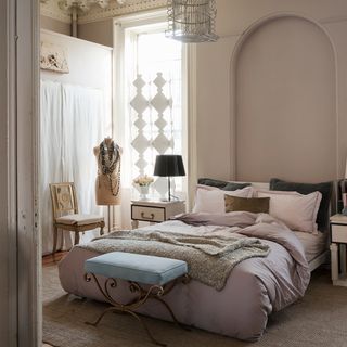 pastel pink and cream luxury bedroom with side table and chair