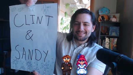 Stardew Valley creator Eric Barone holds up a piece of paper saying "Clint & Sandy"