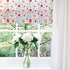 window with glass flower vase and blinds