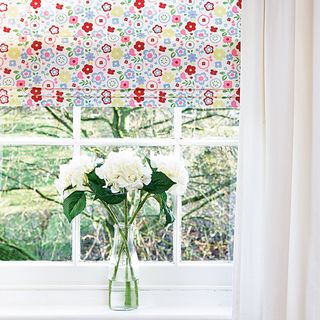 window with glass flower vase and blinds