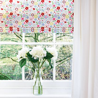 window with glass flower vase and blinds