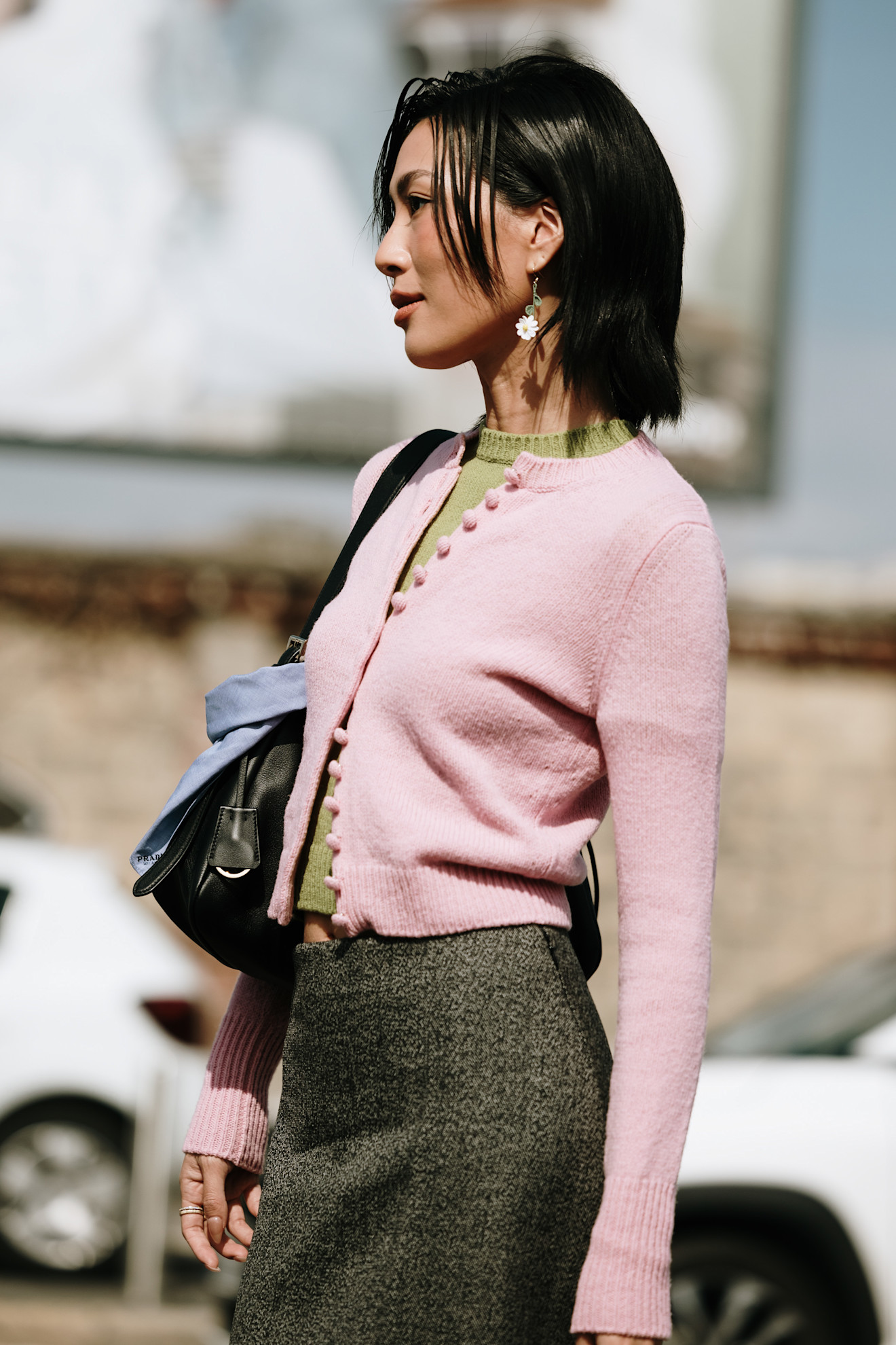 Woman in a pink cardigan over a green crewneck sweater