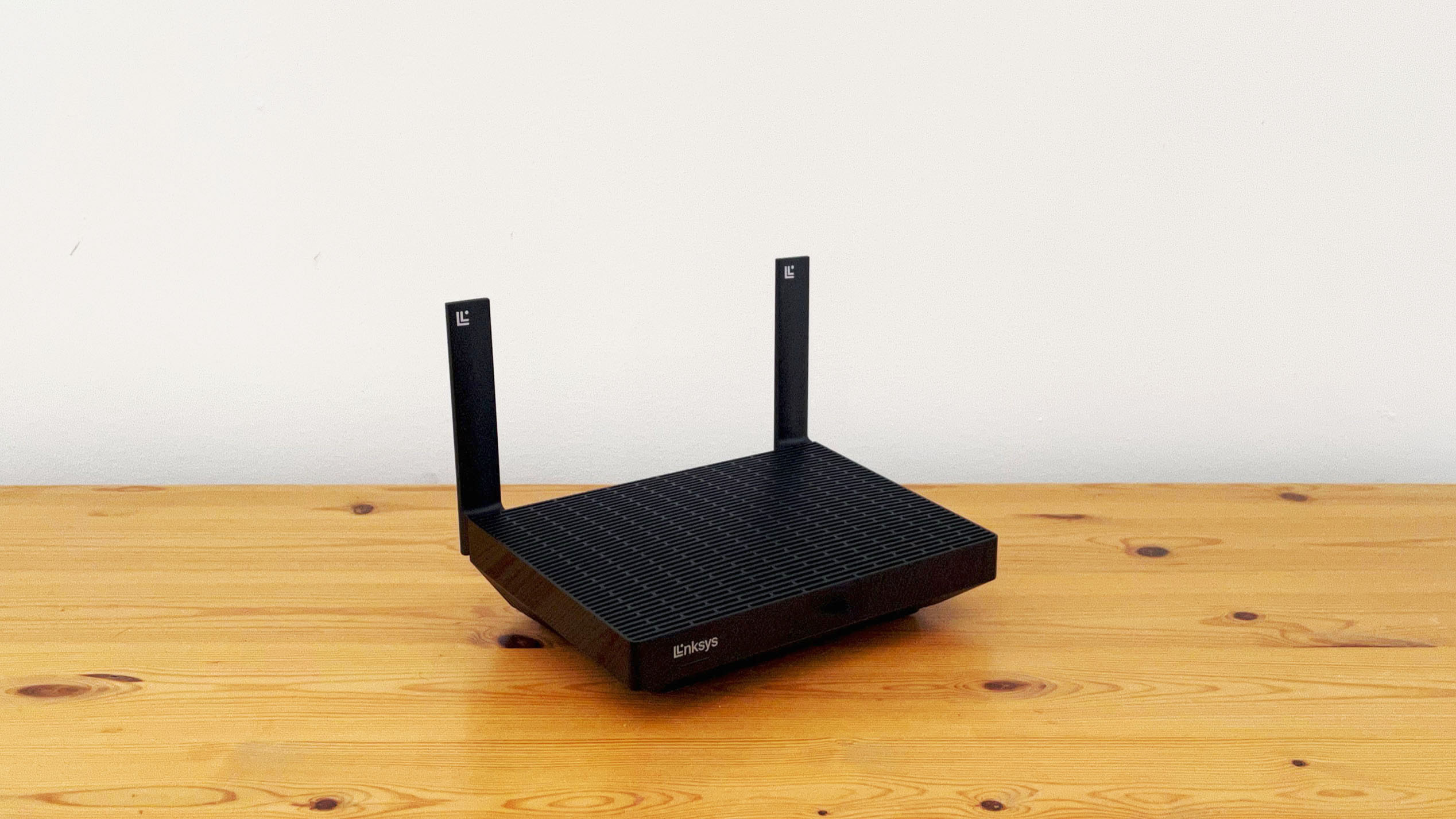 Linksys Hydra Pro 6 router on a wooden desk.