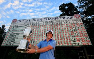 Rory McIlroy holds the US Open trophy in front of the leaderboard in 2011