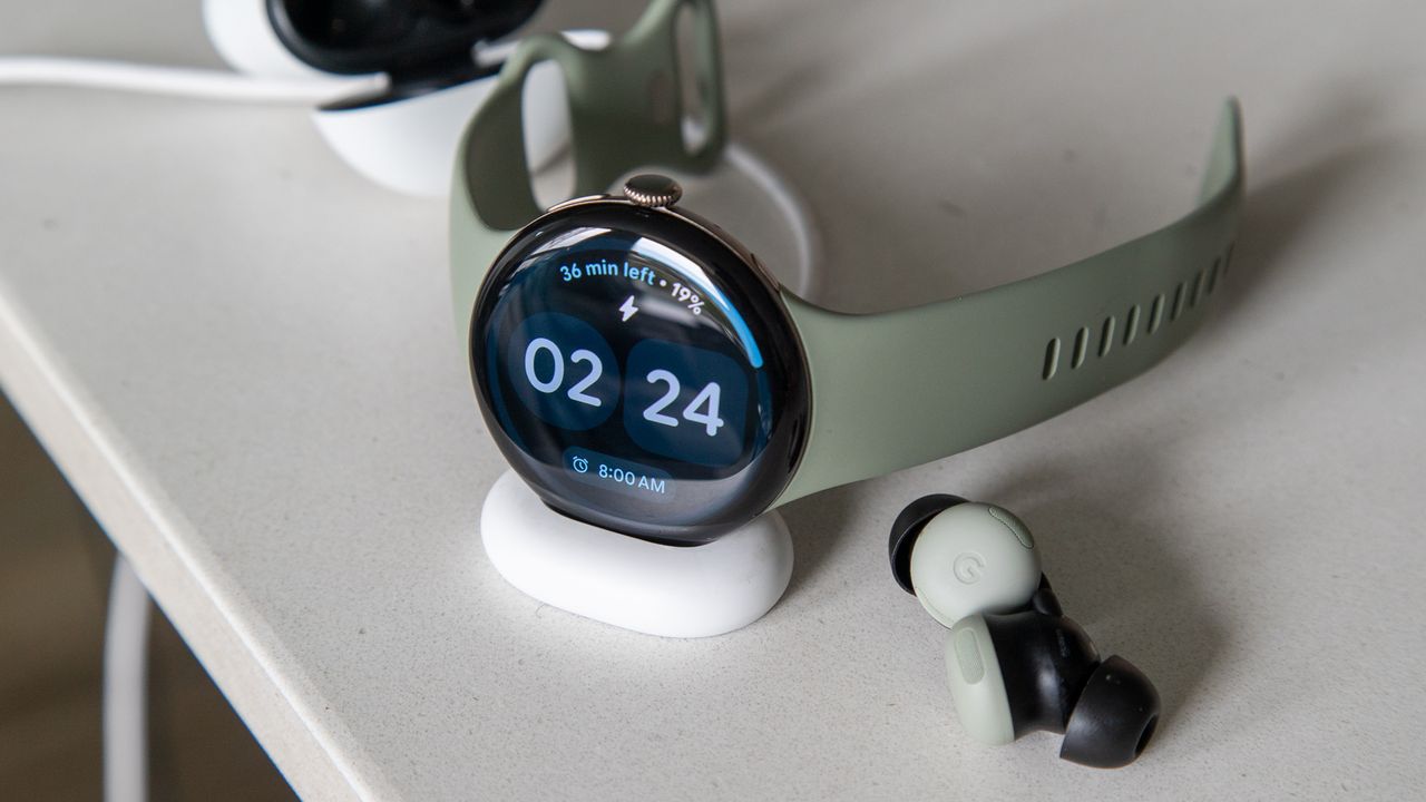 The Pixel Watch 5 charging next to the Pixel Buds 2 Pro