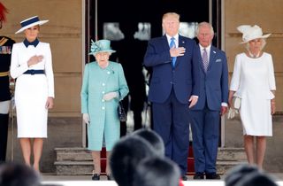 Melania Trump, Queen Elizabeth, Donald Trump, King Charles and Queen Camilla standing next to each other in dresses and suits outside