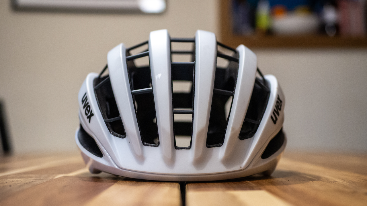 A white Uvex Surge helmet stands on a wooden table
