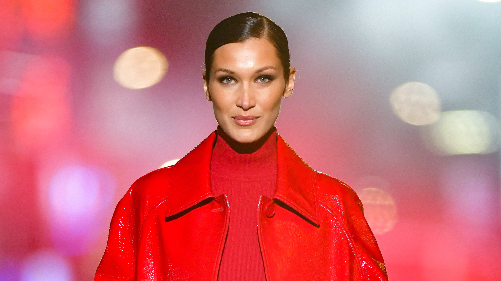 Bella Hadid wearing a red jacket and red top on the runway in 2021 for Michael Kors