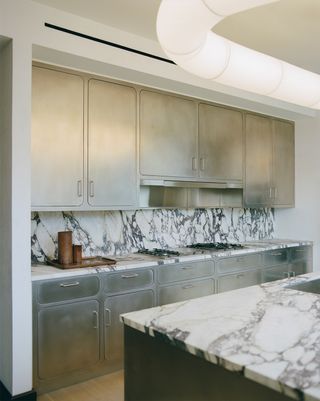 stainless steel kitchen with marble backsplash