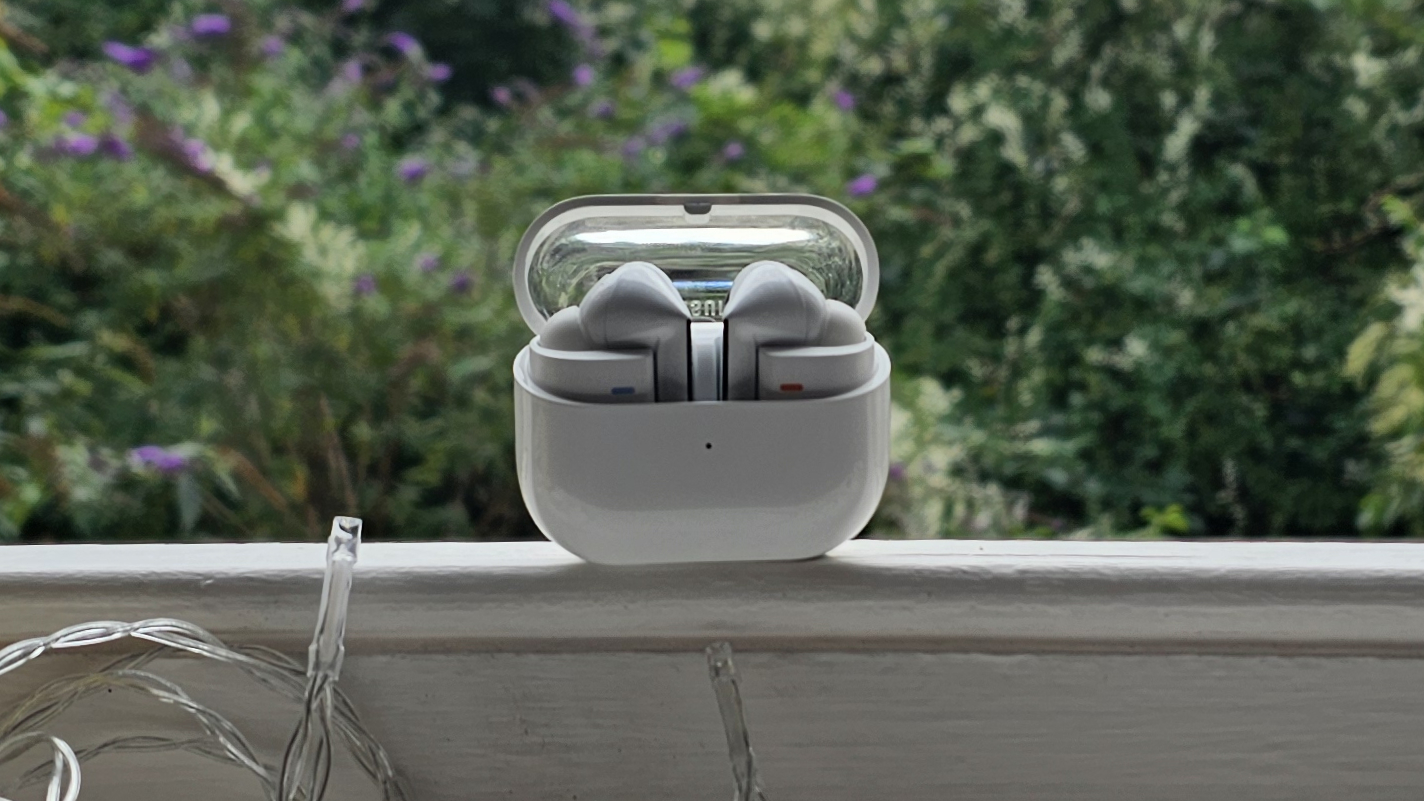 The Samsung Galaxy Buds 3 Pro against a leafy background.