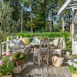 outdoor dining area on a decked veranda surrounded by woodland