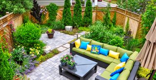 small backyard with central seating area with corner sofa to create a focal point following an essential small garden tip