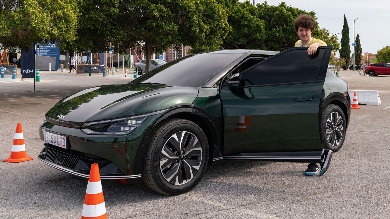 Man standing at open driver's door of a green EV6