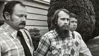 Ron Lafferty (C) is escorted out of the Utah County Court House by Utah County Sheriff Deputies after the first day of jury selection in his murder trial April 25, 1985 in Provo, Utah