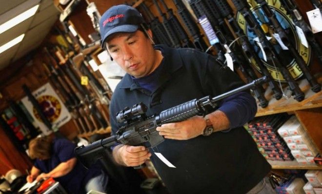 Jason Zielinski shows a customer an AR-15 style rifle at Freddie Bear Sports sporting goods store on December 17, 2012 in Tinley Park, Illinois.